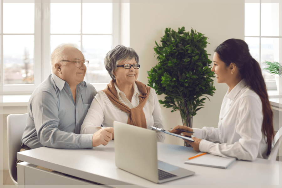 OEP - Senior couple talking to smiling consultant about their health plan - MeetCaregivers