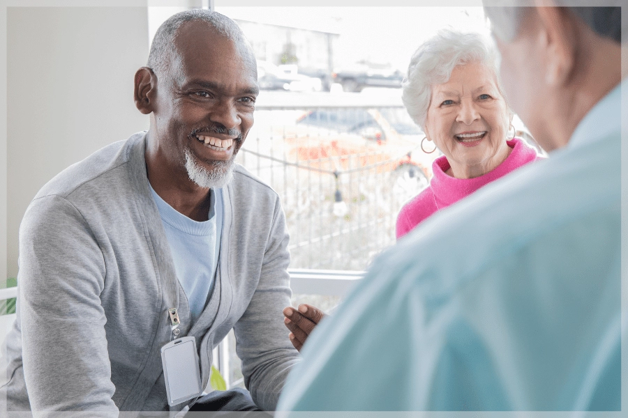 Dementia caregiver support group - Middle Aged Man Speaking To Two Seniors In Group Therapy - MeetCaregivers