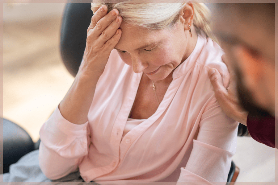 Senior social isolation - Man comforting woman with severe headache - MeetCaregivers