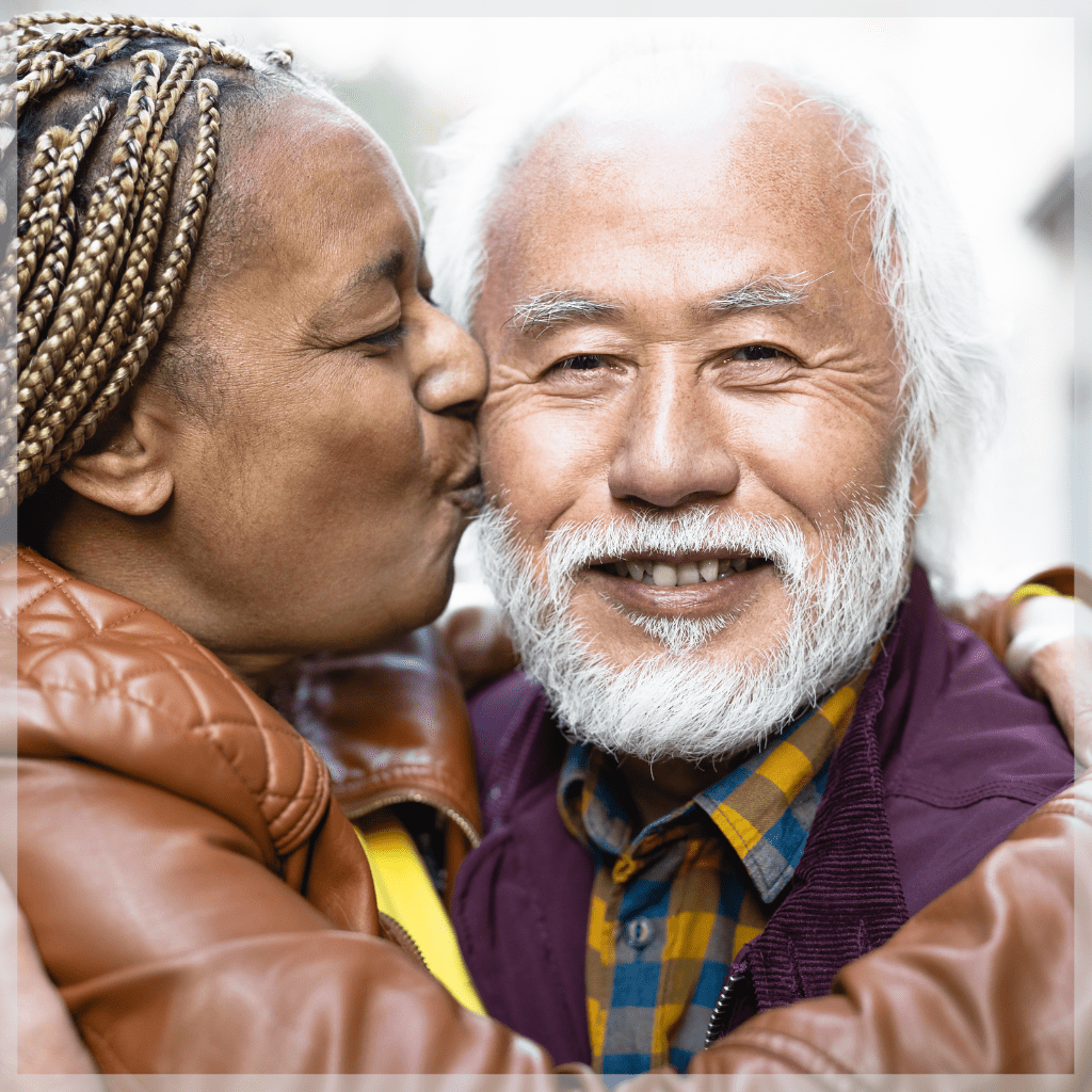 Aging parents - Older woman giving elderly man a kiss on the cheek - MeetCaregivers