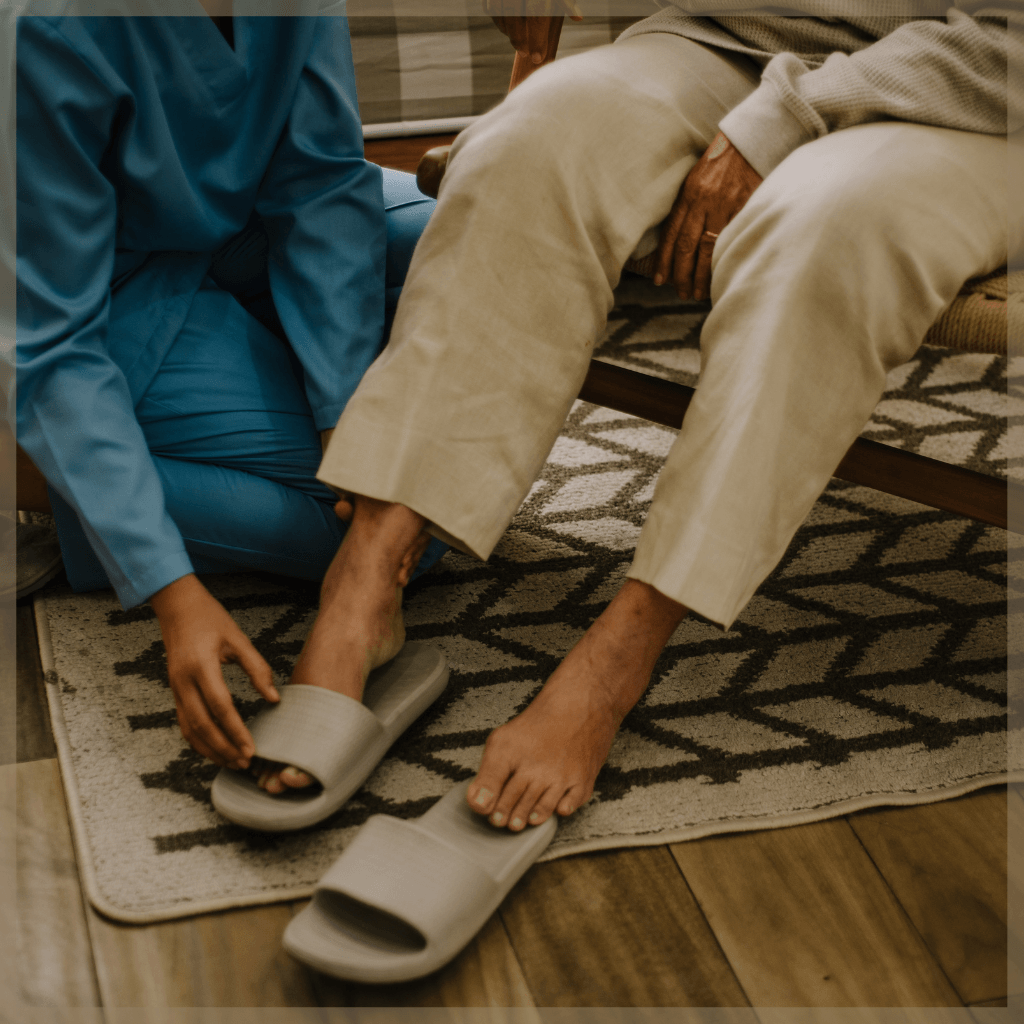 Care Match - Caregiver helping elderly person put on their sandals - MeetCaregivers