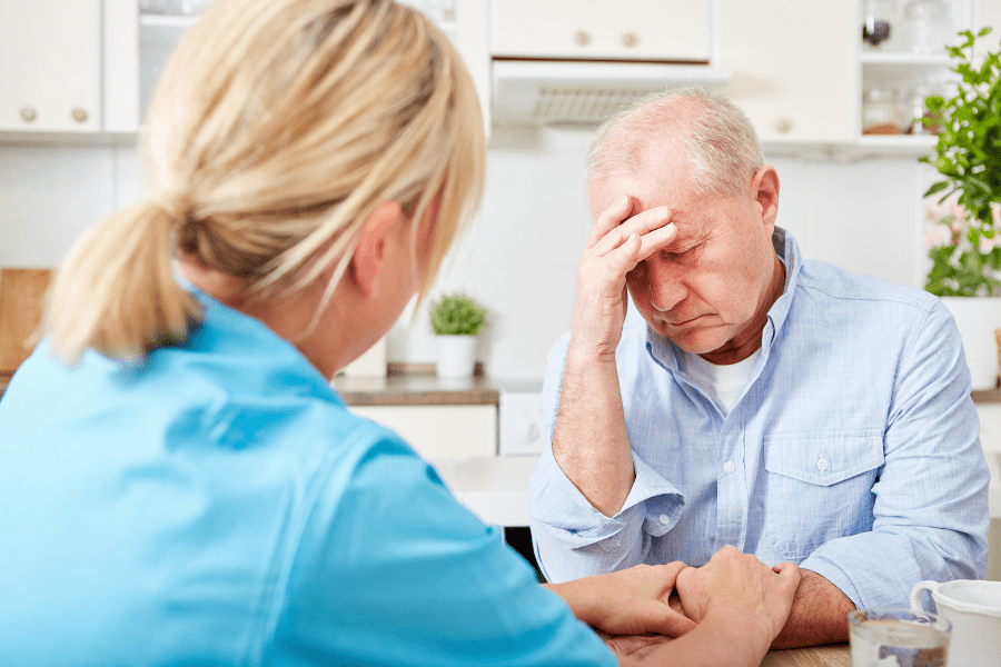 Dementia Home Care Nurse Comforting Senior Man