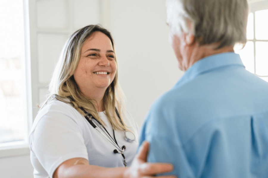 Home health worker talking to senior man about respite care.