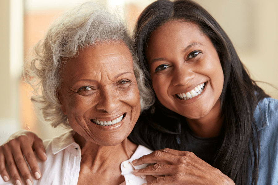 Caregiver burnout – Senior woman and adult daughter smiling and hugging
