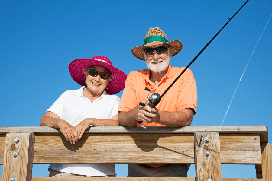senior-couple-obversving-uv-safety-awareness-month-by-wearing-sunhats-and-sunglassess-while-fishing